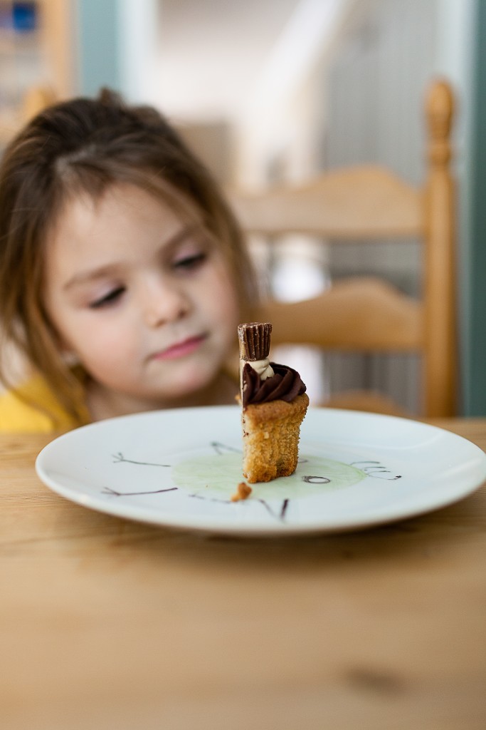 child at table with cupcake